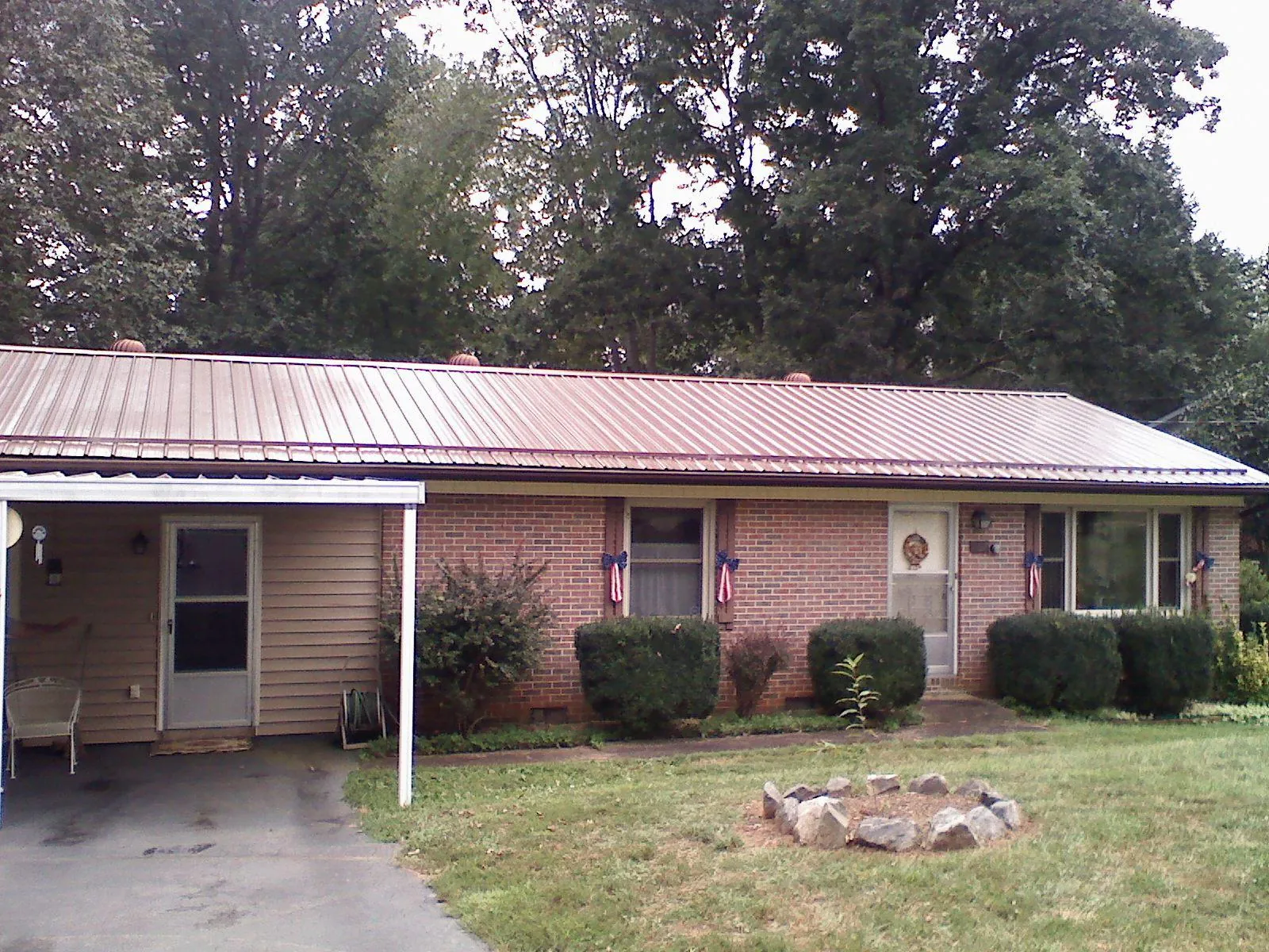 Bronze metal roof and carport on a brick ranch home — Roof Repair work by our crew in Fort Myers
